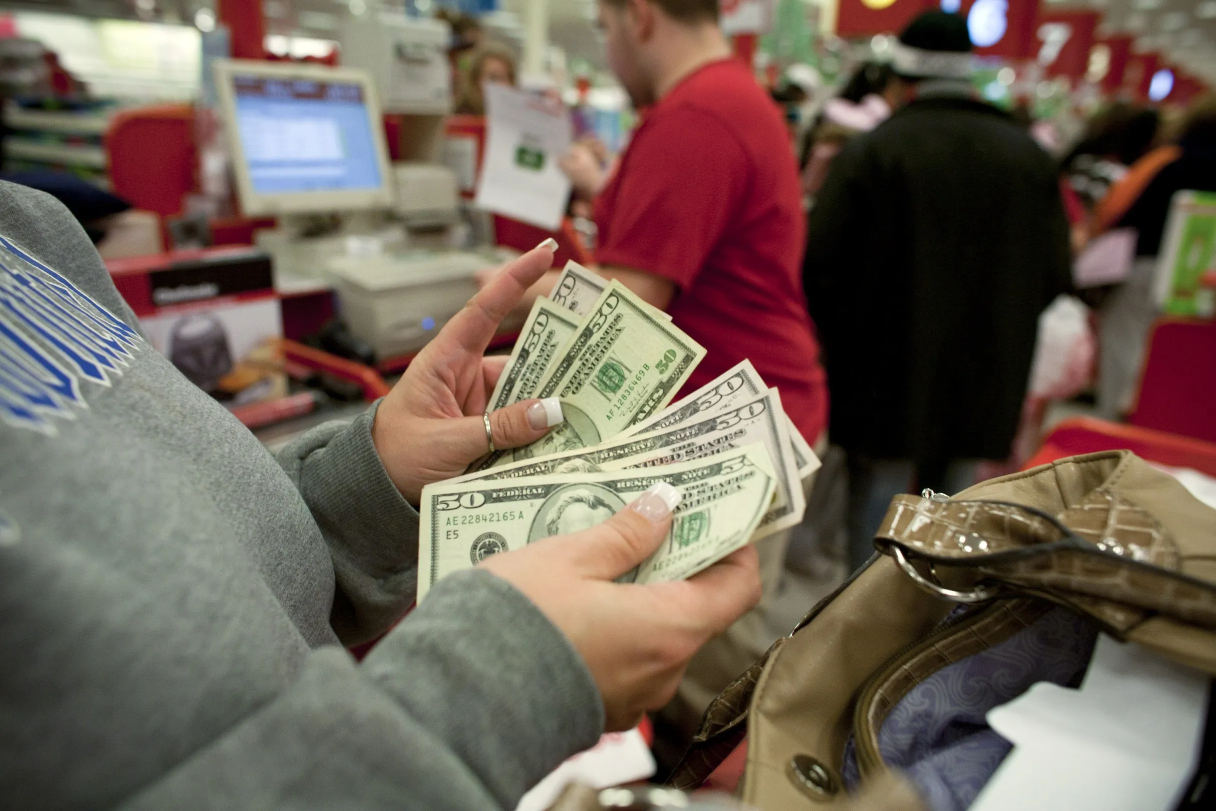 Kim Wolfe pays for her purchases in cash with U.S. $50 dollar notes at a Super Target store in Thornton, Colorado, U.S., on Friday, Nov. 26, 2010. Shoppers on Black Friday, the biggest shopping day of the year, are taking advantage of deals as they face down a slower economic recovery than projected.