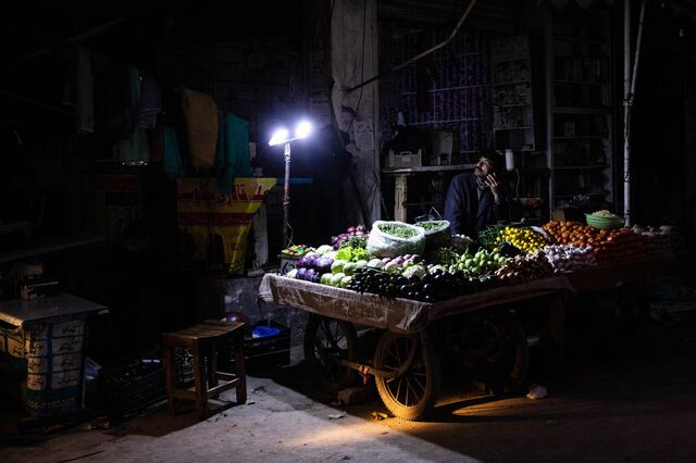 Vendors sell fruit under lights lit by batteries in Lahore, Pakistan