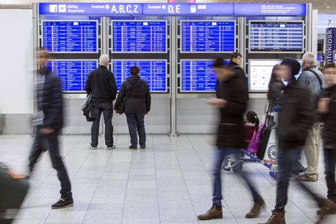 Passengers check an electronic departures board inside Terminal 1 at Frankfurt Airport, operated by Fraport AG, in Frankfurt, Germany, on Monday, Dec. 28, 2015. European stocks climbed in a holiday-shortened week, trimming their worst December drop since 2002. Photographer: Martin Leissl/Bloomberg via Getty Images