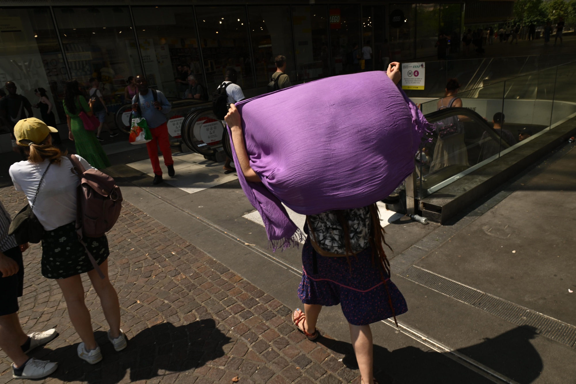 A pedestrian uses a shawl to shield from the sun during high temperatures in Paris, France, on Friday, June 26, 2026. The intense and unusually early heat underscores how climate change is transforming summers in the world’s fastest-warming continent. Photographer: Benjamin Girette/Bloomberg