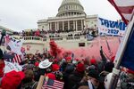 A demonstrator unleashes a smoke grenade in front of the U.S. Capitol building during a protest in Washington, D.C., Jan. 6, 2021.
