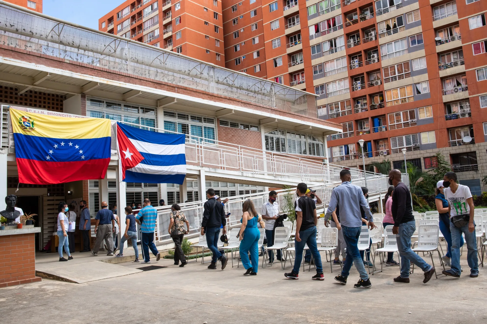 Patients wait in line beneath Venezuelan and Cuban flags to receive the Cuban Abdala Covid-19 vaccine in Caracas on July 1.