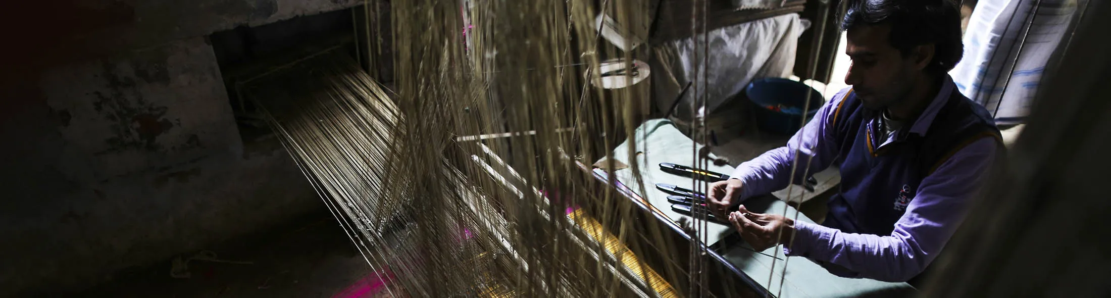 A weaver works on a handloom to make a silk saree at a workshop in Kotwa village in Varanasi, Uttar Pradesh, India, on Thursday Dec. 8, 2016.
