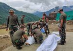 Soldiers wrap bodies of victims of a mudslide in Noney, northeastern Manipur state, India, Friday, July 1, 2022. Rescuers found more bodies Friday as they resumed searching for dozens of missing after a mudslide triggered by weeks of heavy downpours killed at least 19 people at a railroad construction site in India's northeast, officials said. (AP Photo/Agui Kamei)