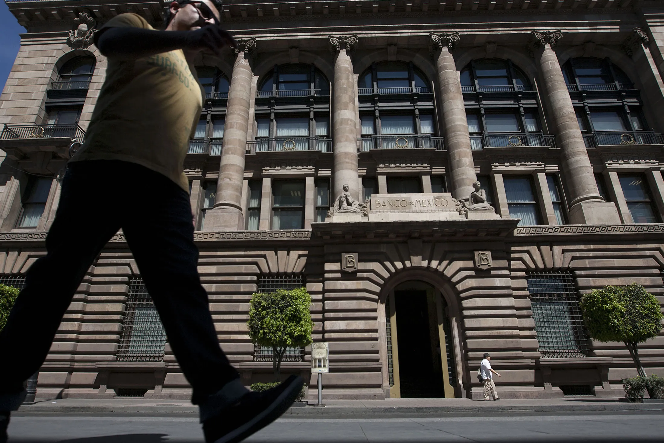 Pedestrians walk by the Banco de Mexico building in Mexico city, Mexico, on Wednesday, Feb. 27, 2013.
