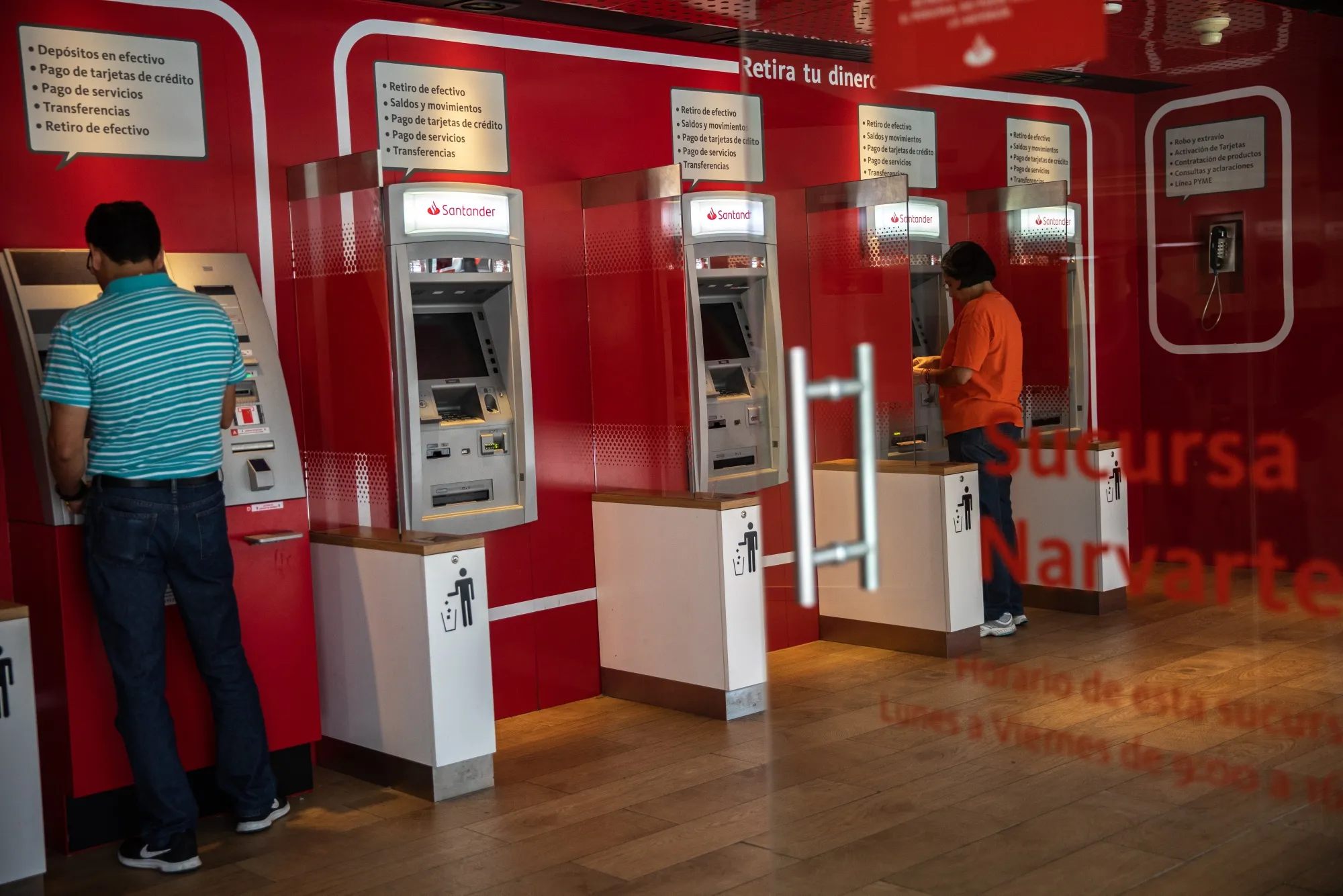Customers use automatic teller machines (ATM) at a Grupo Financiero Santander Mexico SAB bank branch in Mexico City, Mexico, on Friday, Nov. 9, 2018.