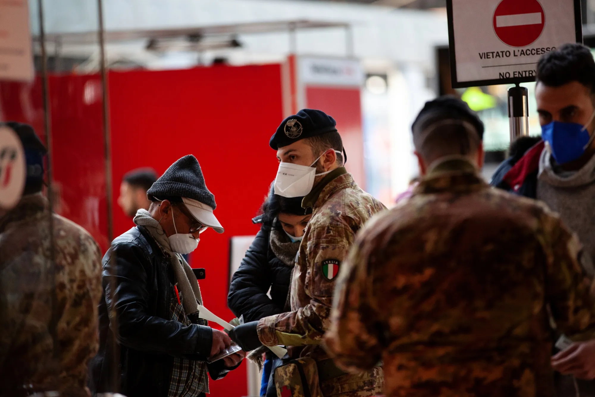 In Milan, members of the military check commuters' travel authorization forms.