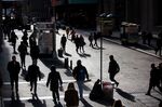 Pedestrians walk along Wall Street near the New York Stock Exchange (NYSE) in New York, U.S.