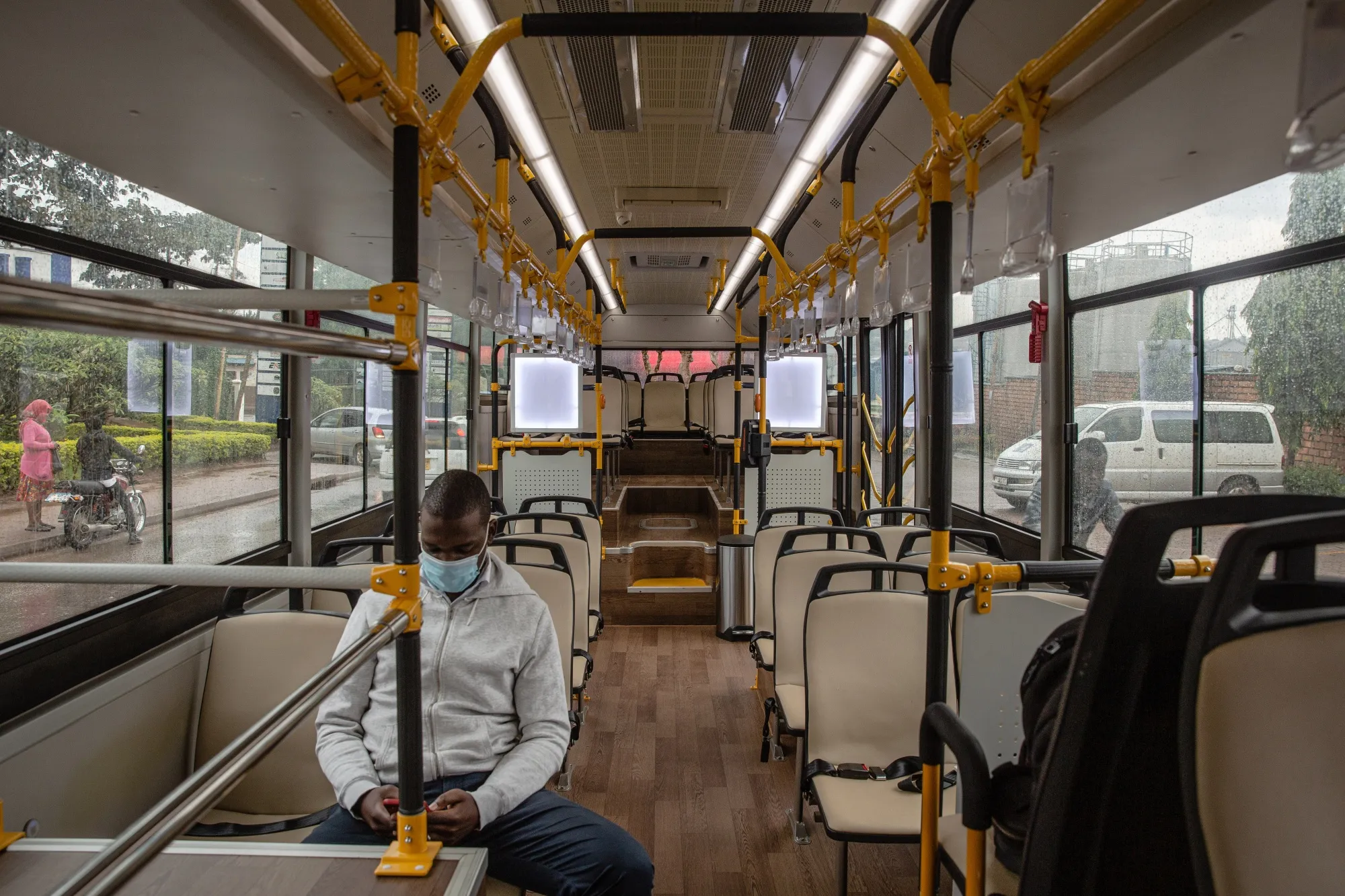 A passenger wearing a protective face mask sits aboard an electric bus in Kampala, Uganda.