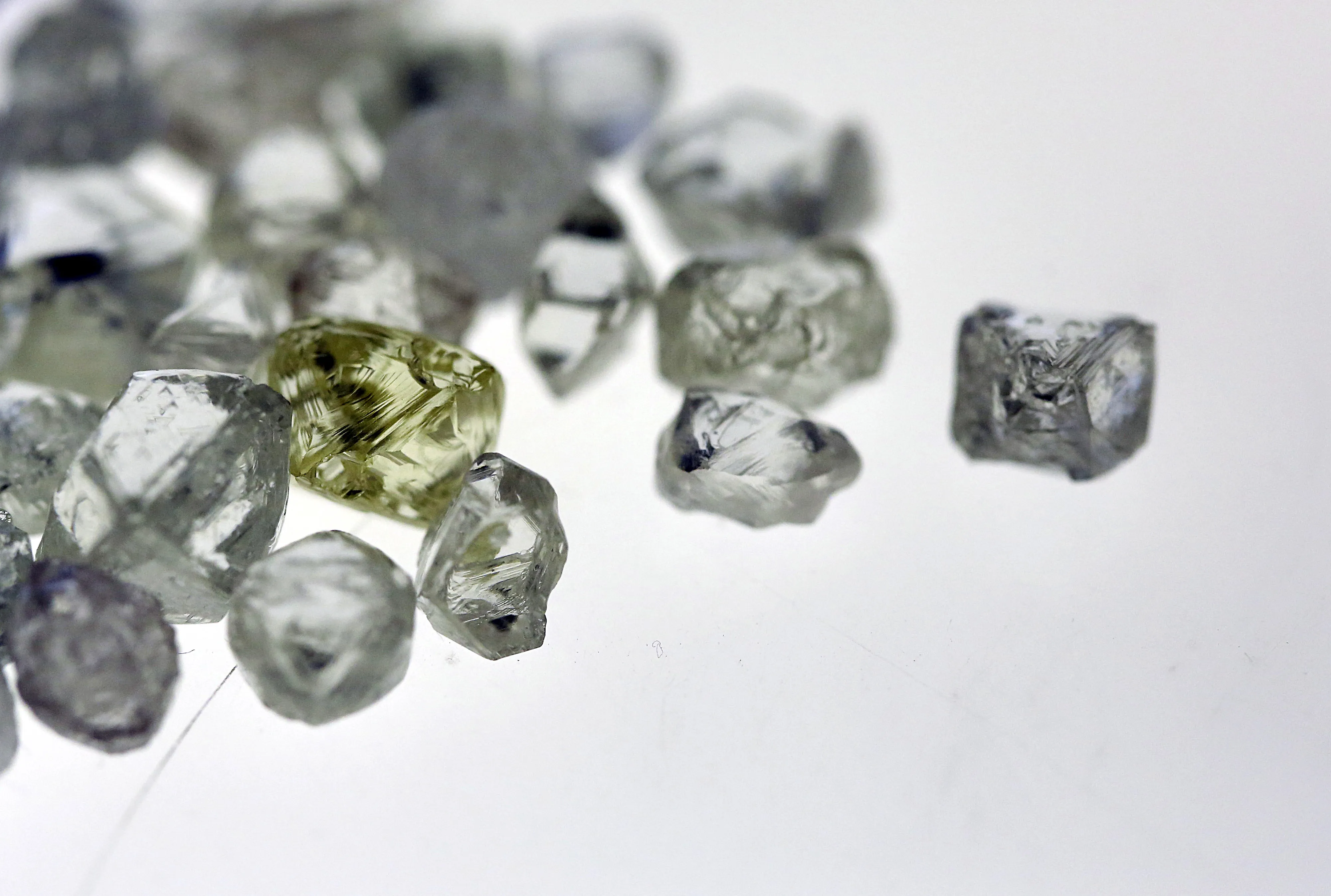 A pile of colorless and colored uncut diamonds sit on a sorting table before processing at DTC Botswana, a unit of De Beers, in Gaborone, Botswana.
