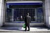 A pedestrian looks at an electronic stock board outside a securities firm in Tokyo, Japan, on Thursday, Dec. 20, 2018. Japanese stocks entered a bear market as the last policy statements of the year from the Federal Reserve and Bank of Japan added to mounting investor concerns.