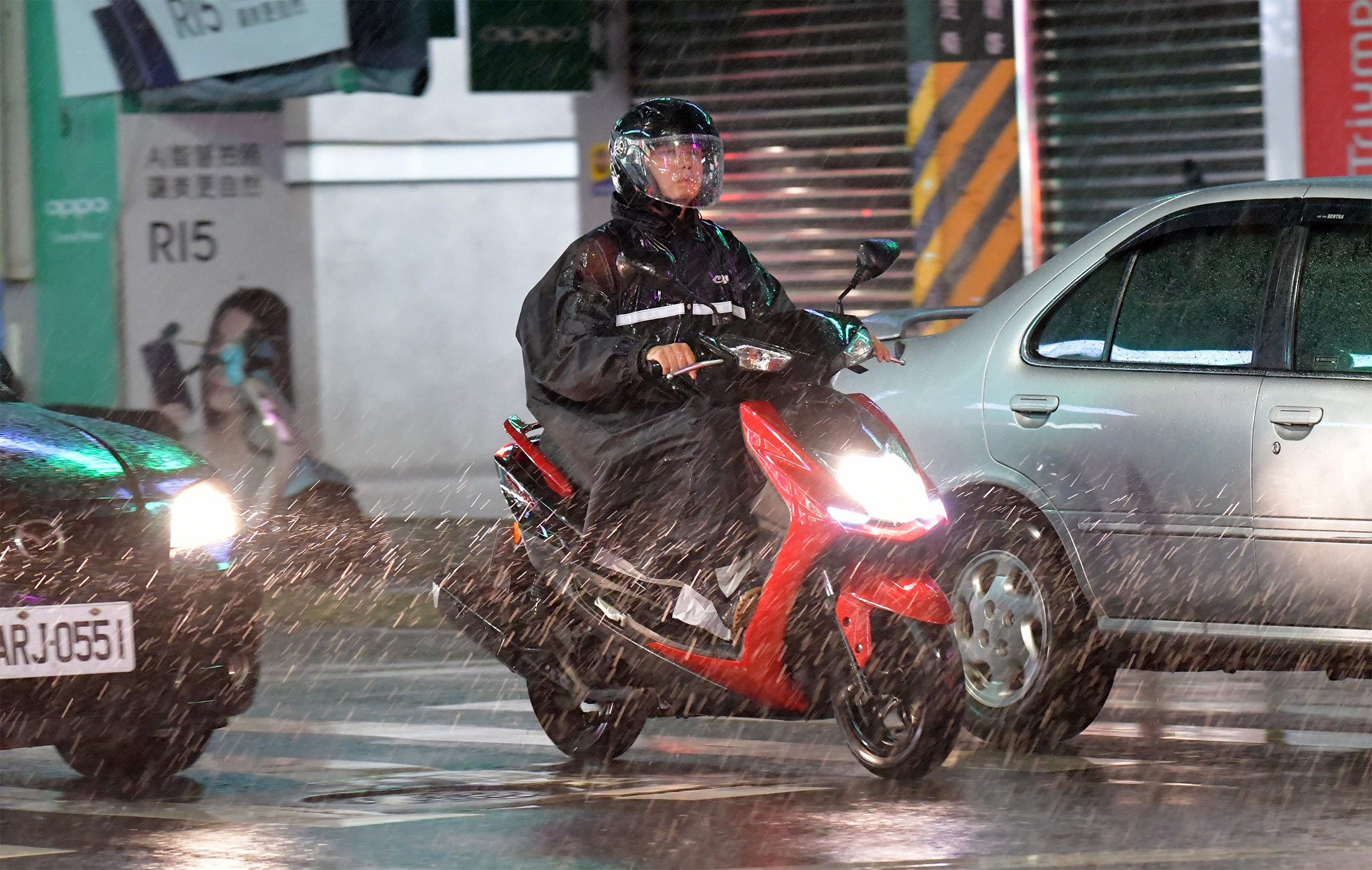 A motorcyclist rides through heavy rain in Keelung on July 10.