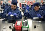 Employees work on stent graft components in a sterile environment at the Medtronic Inc. assembly plant in Tijuana, Mexico, on Oct. 27, 2014.
