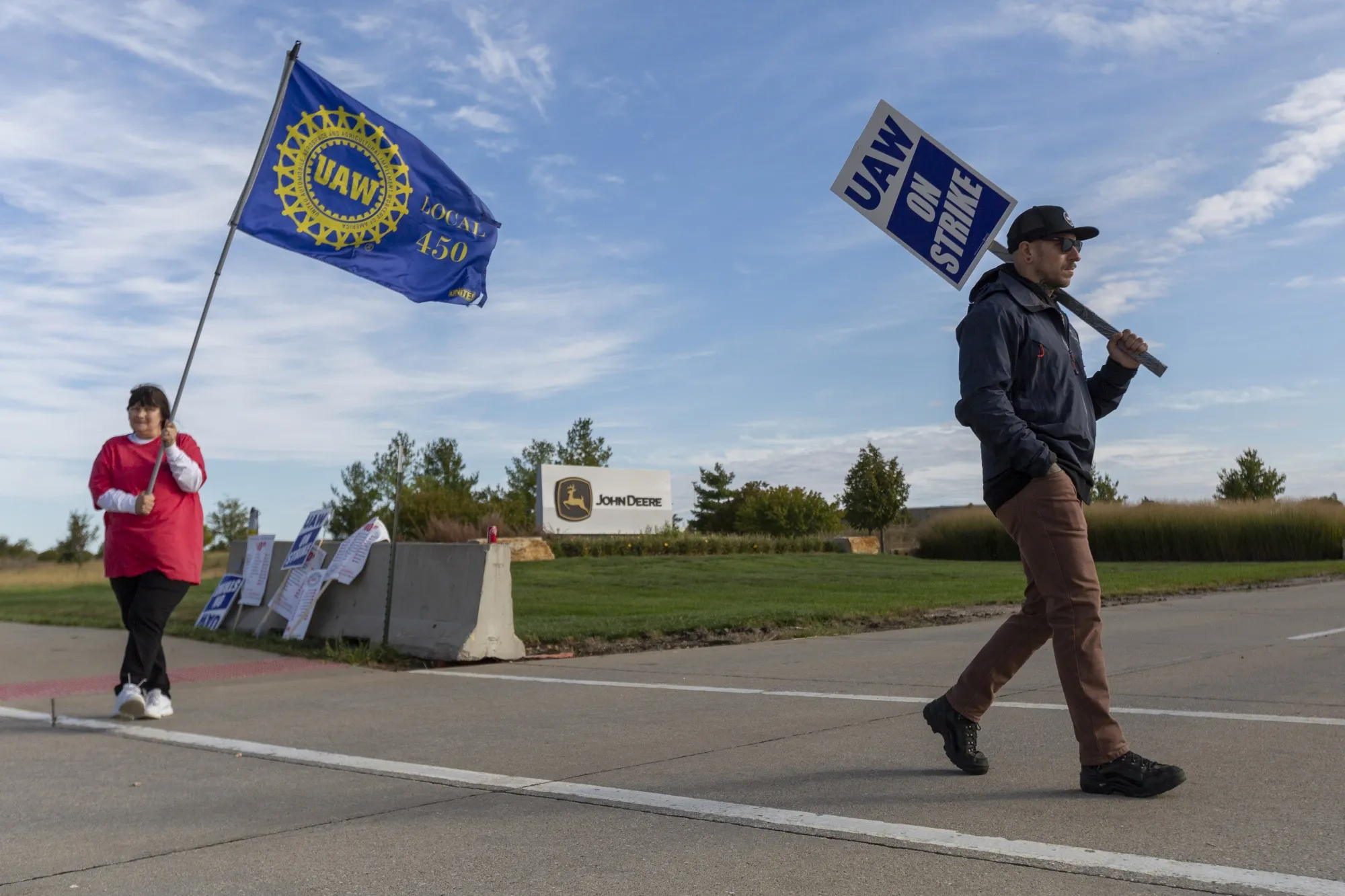 Deere &amp; Co. workers hold signs during a strike outside the John Deere Des Moines Works facility in Ankeny, Iowa, on&nbsp;Oct. 15.