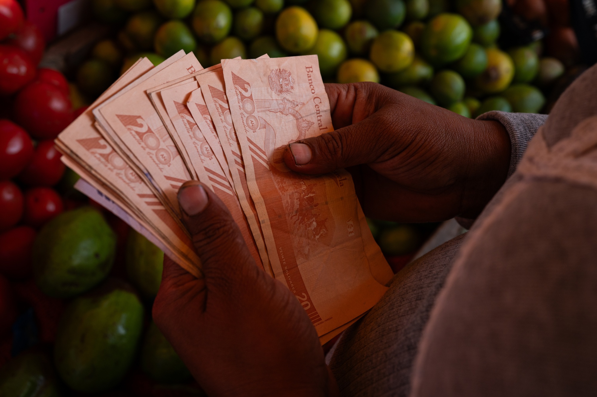A woman counts bolivar banknotes at the Coche market in Caracas.