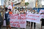 Protesters hold a banner supporting the National Unity Government in Yangon.
