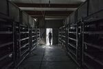 A technician exits a warehouse containing bitcoin mining machines at a mining facility.