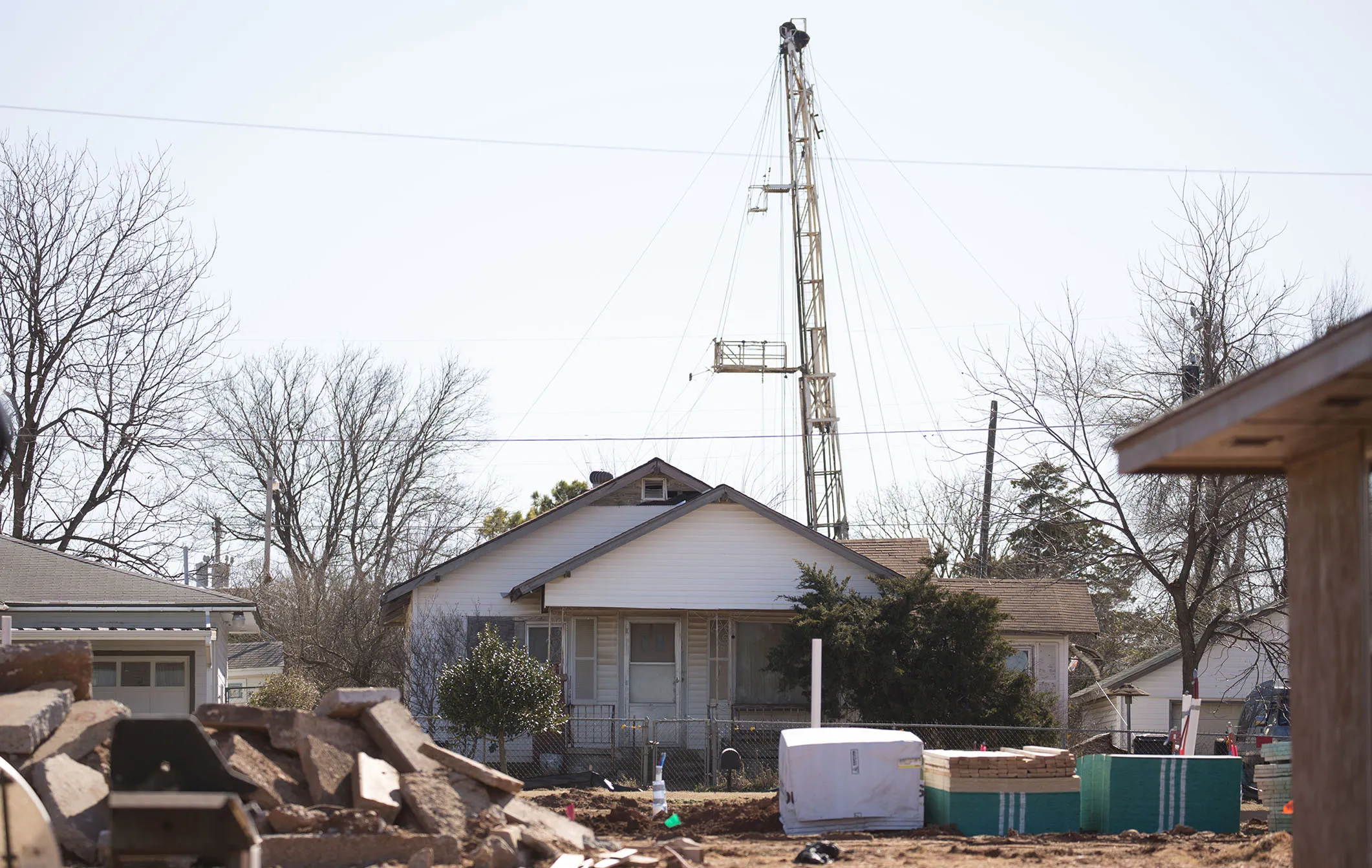 A fracking oil rig stands behind a home in Oklahoma City.