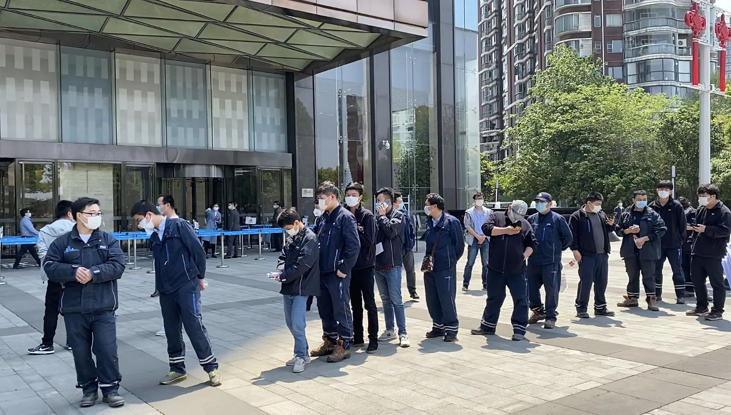 Kone employees line up outside the company’s office building in Wuhan, April 9.