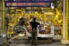An employee handles a side panel for an Infiniti Q30 on the production line at Nissan's plant in Sunderland.