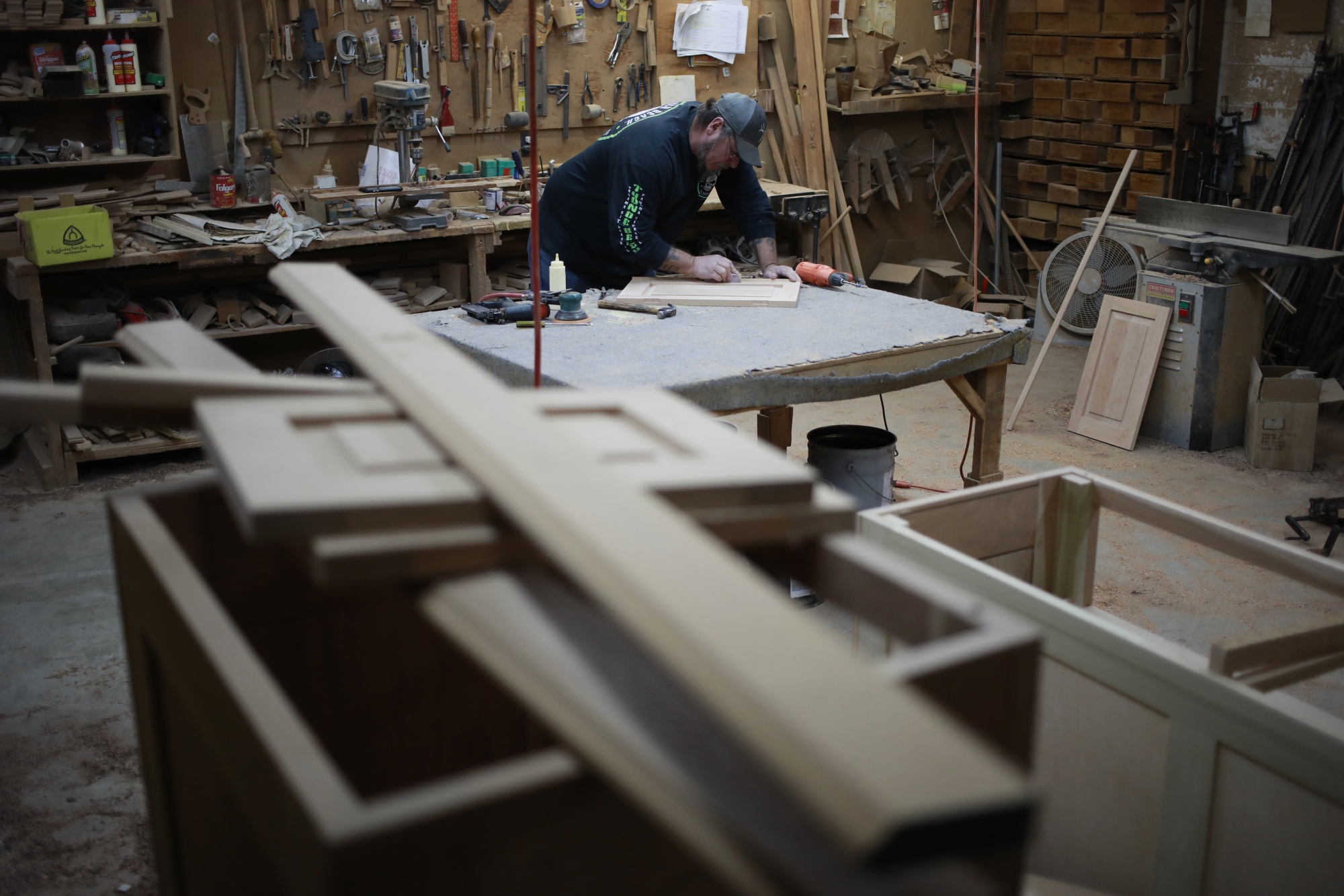 A factory worker assembles a wooden cabinet drawer at a wood shop in Auburn, Kentucky.