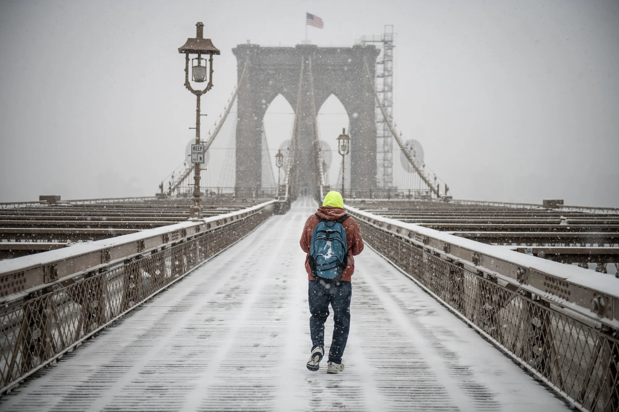 A commuter walks across the Brooklyn Bridge during a winter storm in New York, on Feb. 18.