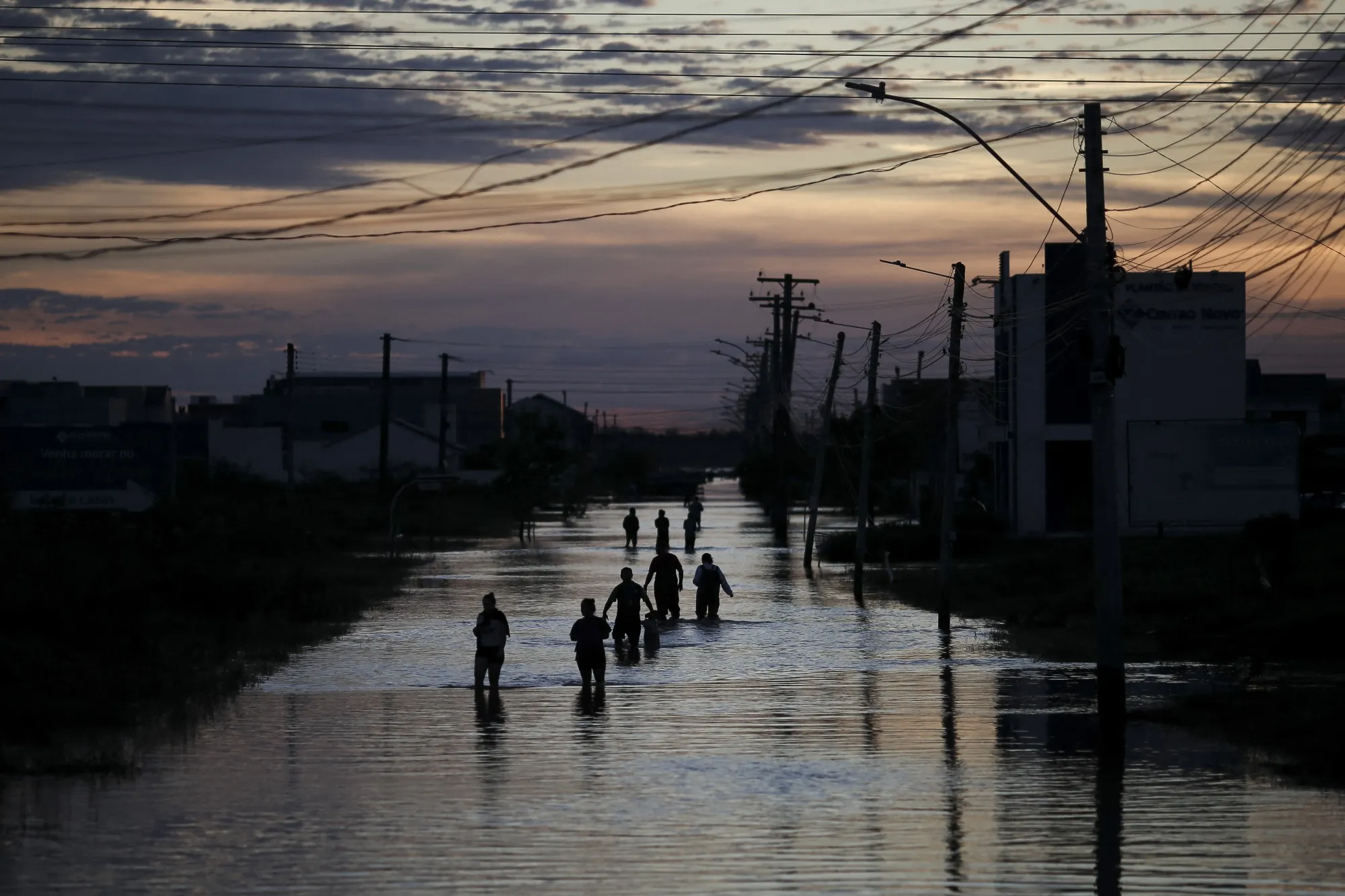People walk along a flooded street in Eldorado do Sul, Brazil, on May 9.