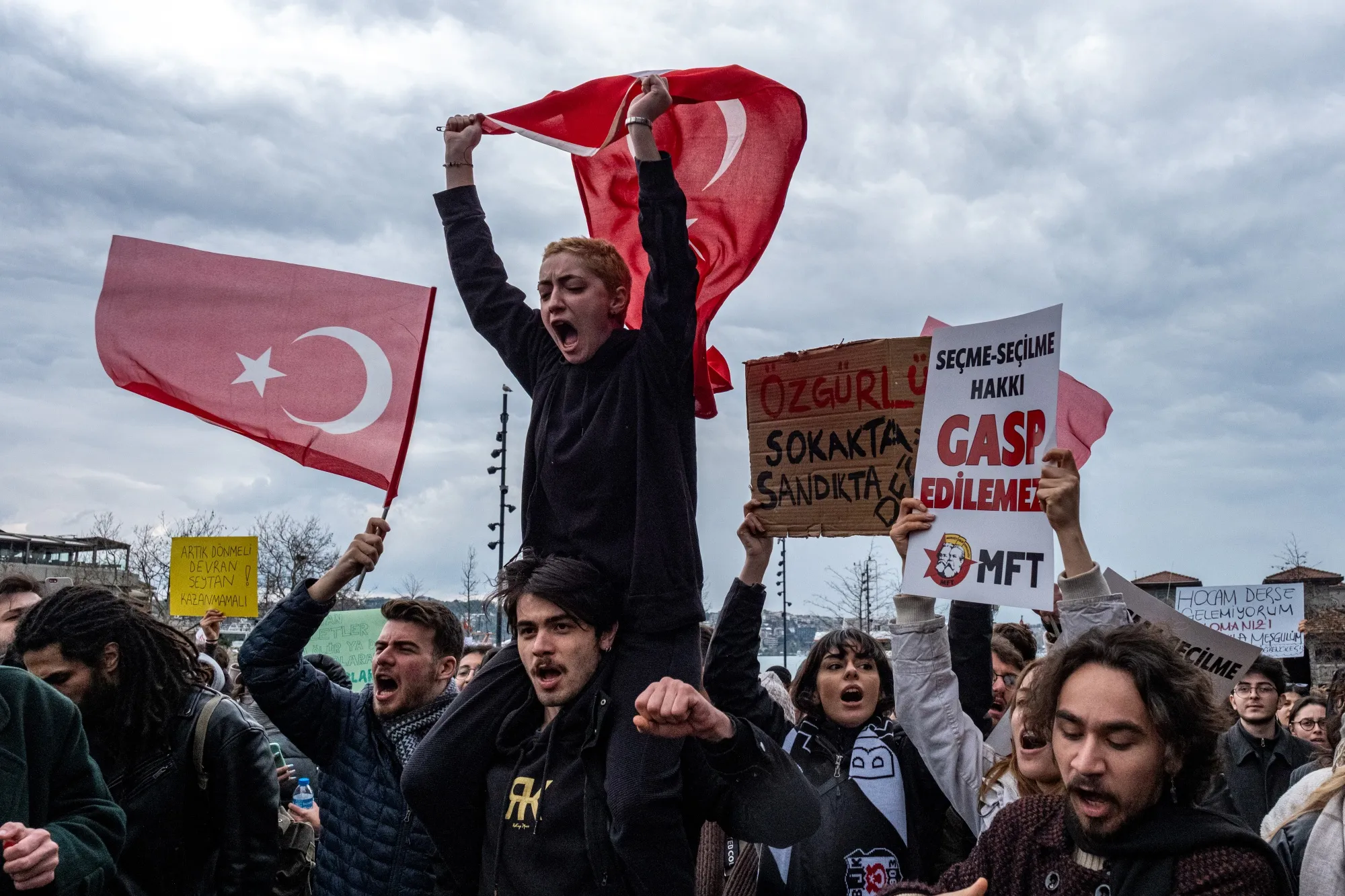 Estudiantes universitarios sostienen banderas y carteles turcos durante una manifestación tras la detención de Ekrem Imamoglu, alcalde de Estambul.