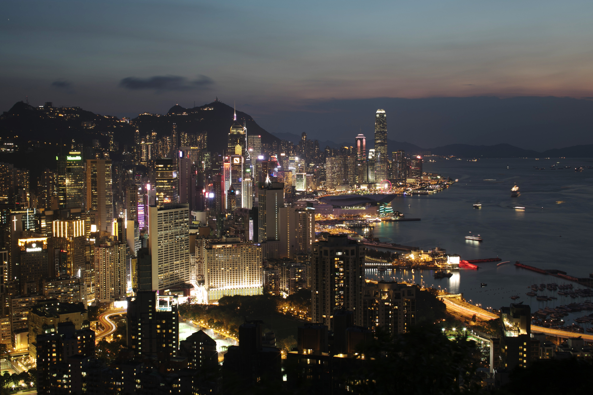 Buildings stand illuminated at dusk in Hong Kong.