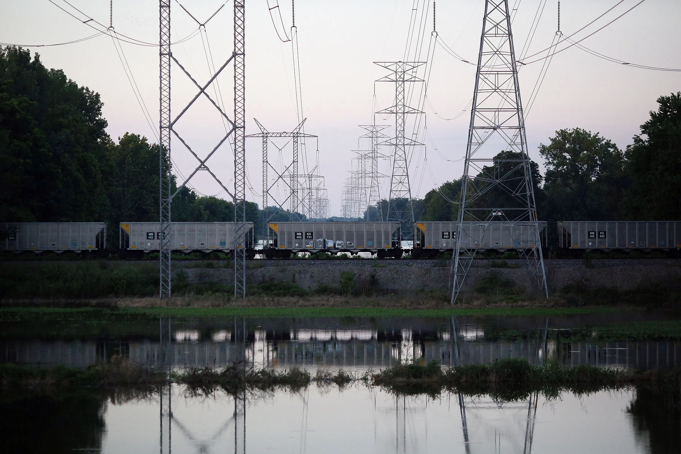 An empty coal train passes underneath power lines leading away from the Duke Energy Corp. Gibson Station power plant in Owensville, Indiana, in 2015.&nbsp;