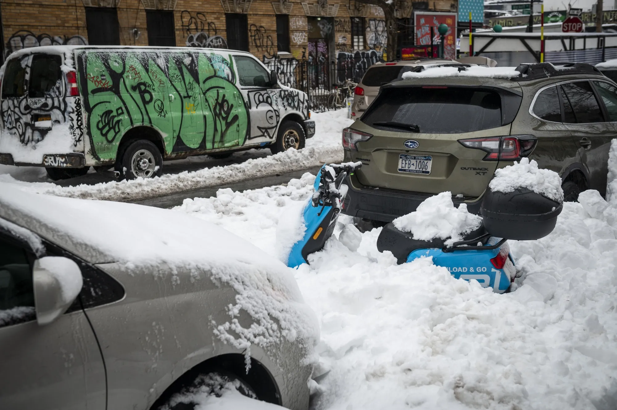 Cars and a scooter in Brooklyn covered in snow after a nor’easter on Feb. 2, 2021.&nbsp;