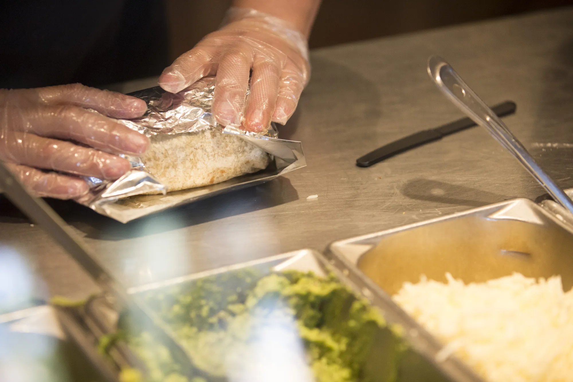 An employee wraps a burrito for an order at a Chipotle Mexican Grill Inc. restaurant in Tempe, Arizona, U.S., on Saturday, Oct. 21, 2017.