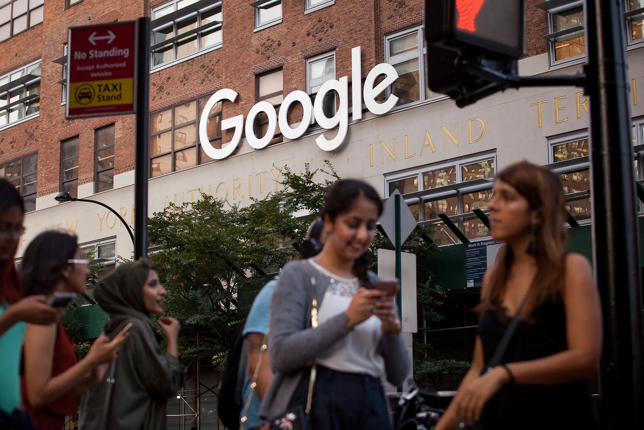Pedestrians walk past the Google Inc. offices in New York.