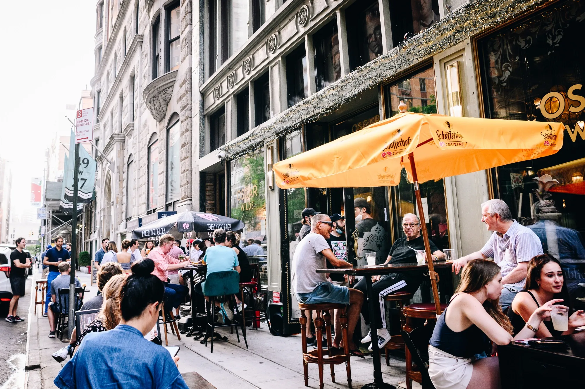 People sit outside during happy hour at the Oscar Wilde bar in New York, on June 10.