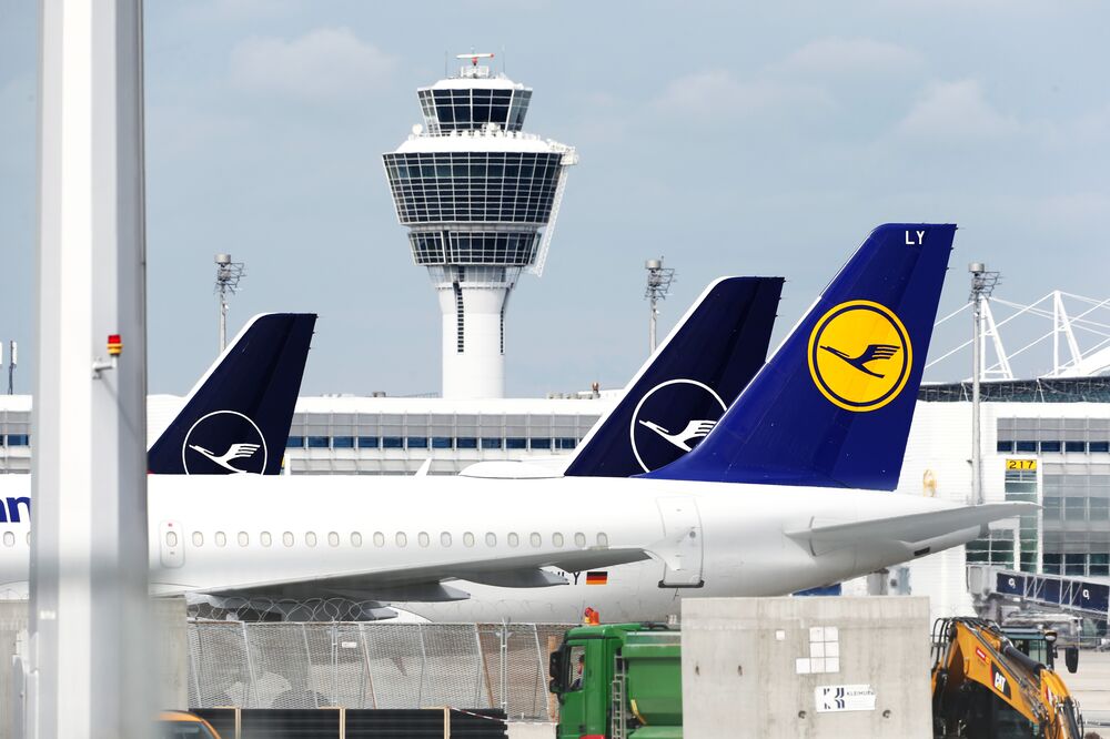 Grounded Deutsche Lufthansa AG passenger aircraft sit near the control tower at Munich Airport in Munich.