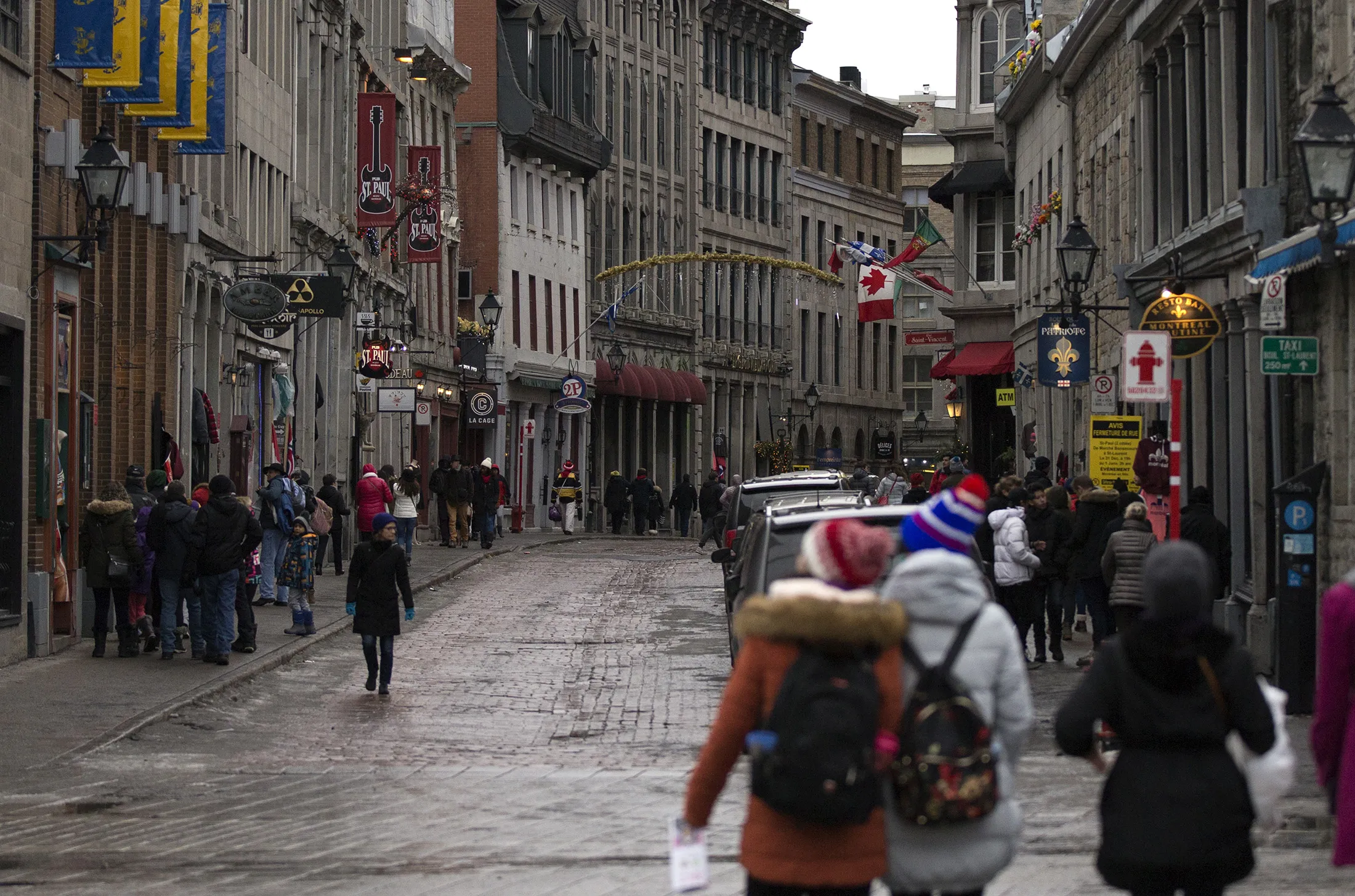 Pedestrians walk through Rue Saint-Paul in Old Montreal, Quebec.