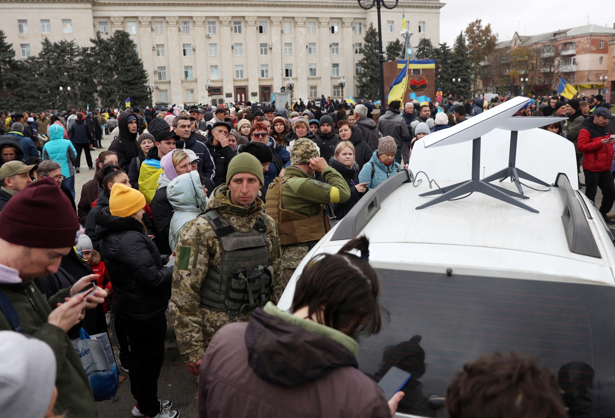 Ukrainians use mobile phones near a Starlink satellite-based broadband station in Kherson, Ukraine. Photographer: AFP/Getty Images