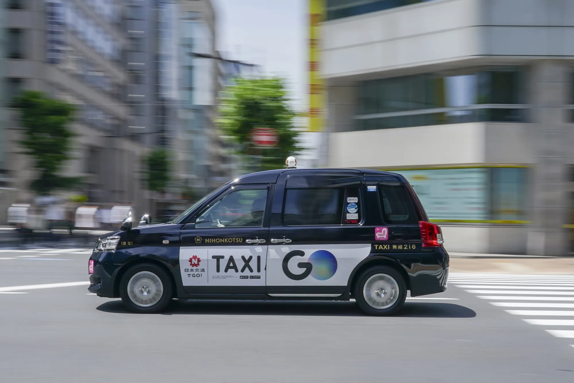 A taxi with a Go Inc. ad in Tokyo.