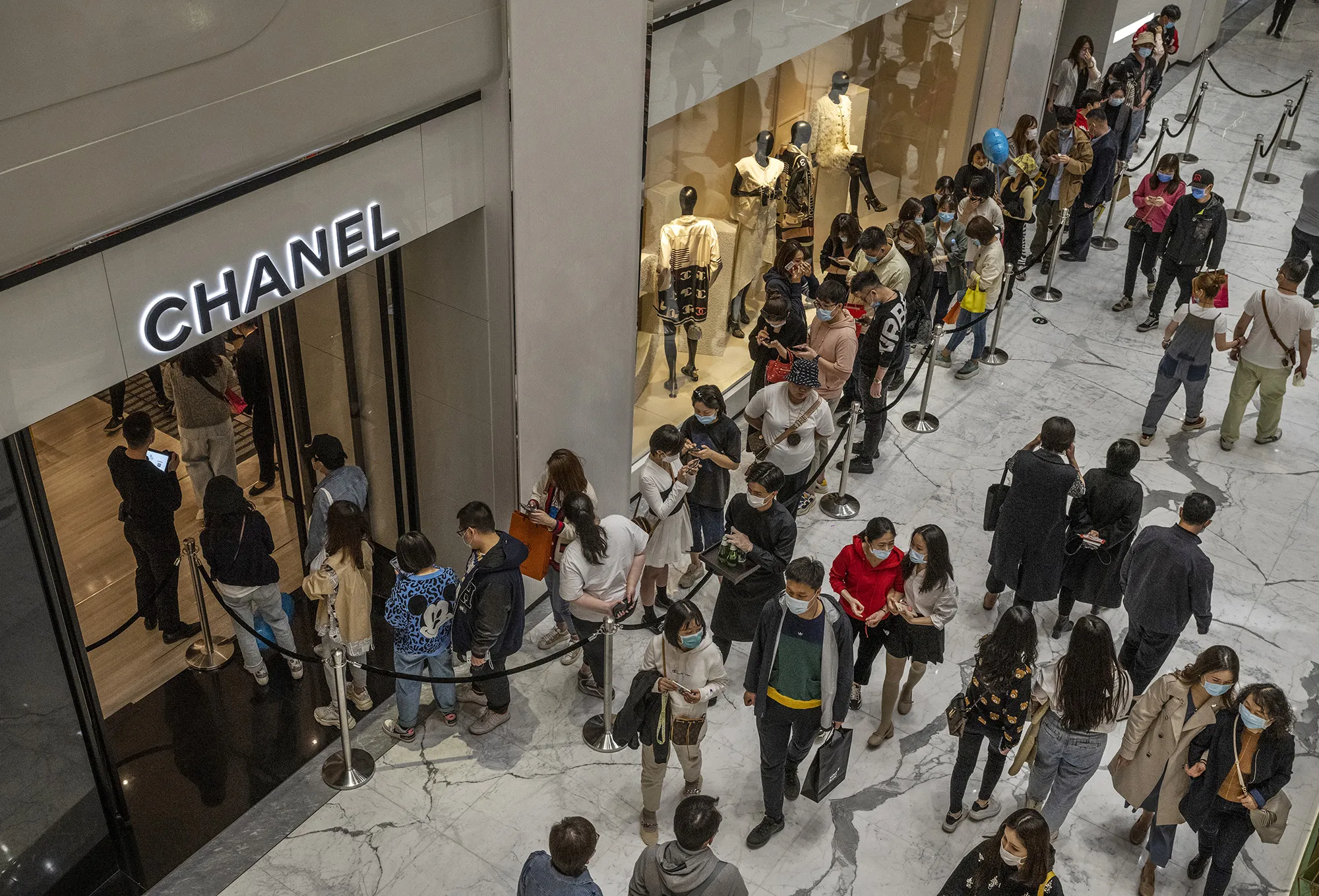 Shoppers wait in line outside a Chanel store at a mall&nbsp;in Beijing.