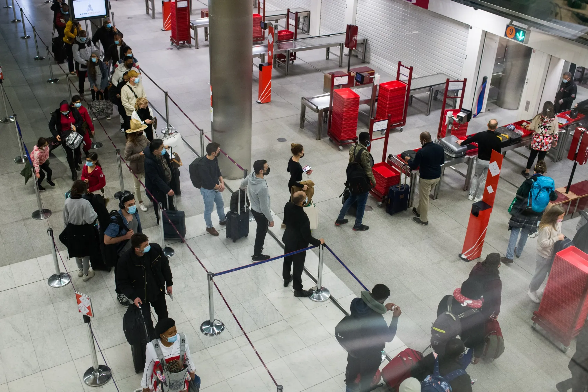 Travelers wait at security gates prior to departure at Paris-Charles de Gaulle airport in Paris.