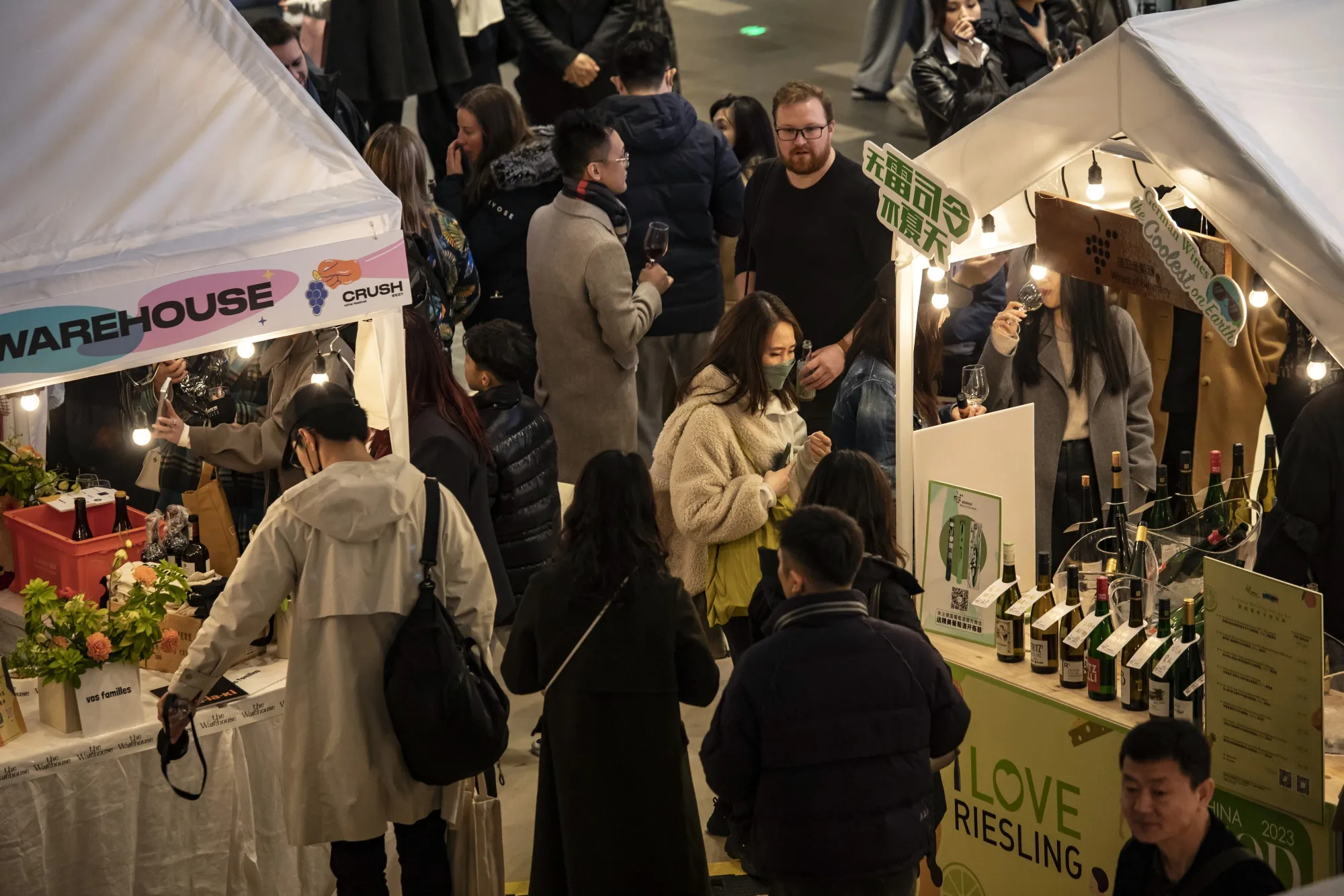 Shoppers browse wine at a night market in the Xintiandi shopping area in Shanghai.