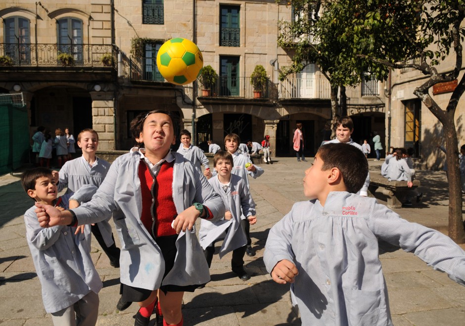 Kids play soccer on a carless street in Pontevedra.