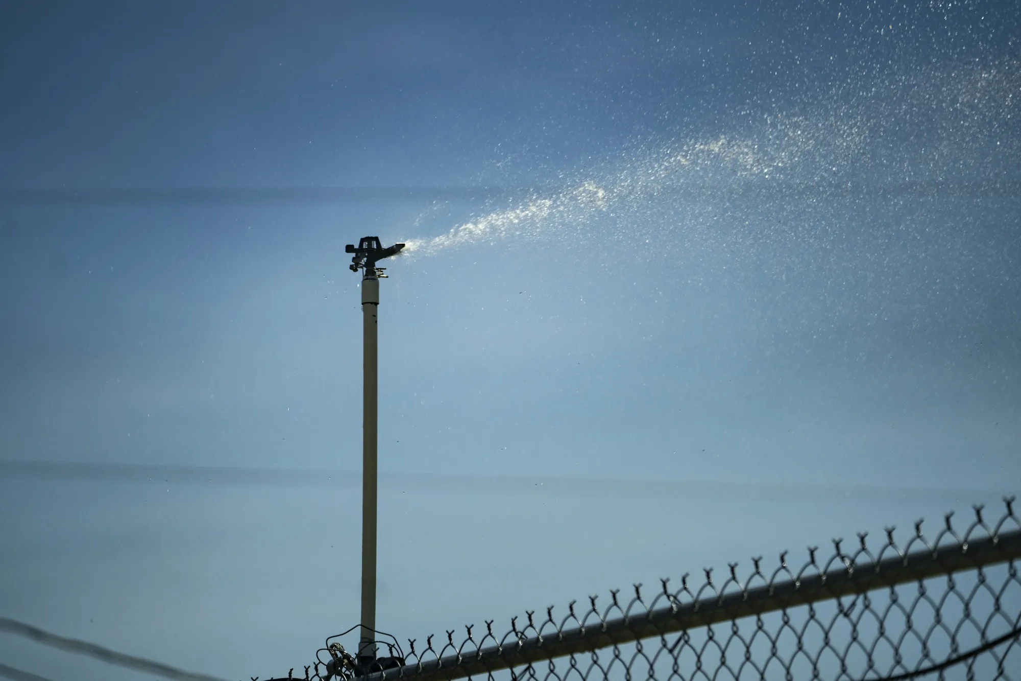 A sprinkler waters a field during a heat wave in Dallas, Texas, US, on Monday, July 25, 2022. It’s back to being
the epicenter as excessive heat warnings come up across the US.