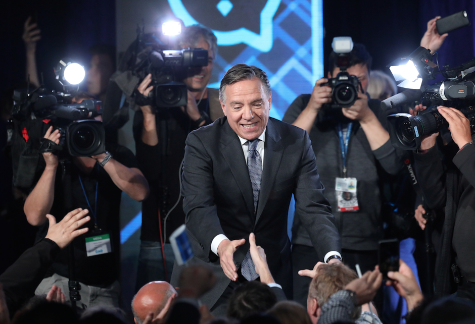 Coalition Avenir Québec (CAQ) party leader Legault shakes hands with supporters in Quebec City after his election night victory.