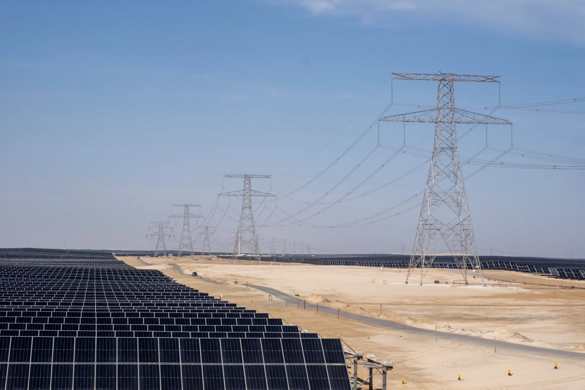 High tension power lines and solar panels at the Dhafra solar power plant near Abu Dhabi, United Arab Emirates. Fourth Power in looking to store energy generated by renewables as heat for hours to days.