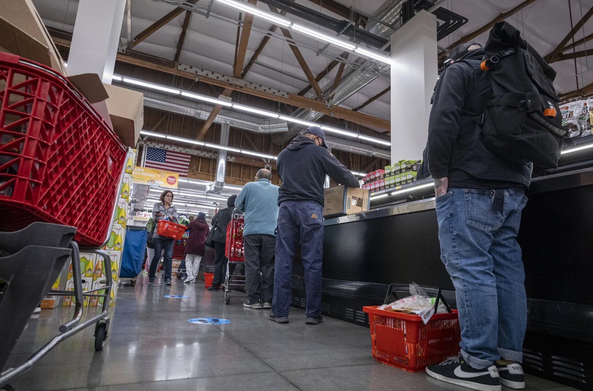 Shoppers wait in line to checkout inside a grocery store in San Francisco, California.