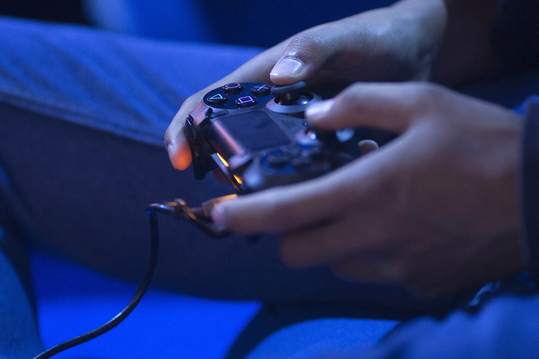 A gamer uses a Sony Corp. Playstation 4 controller to play a video game at EGX 2015 video gaming conference in Birmingham, U.K., on Thursday, Sept. 24, 2015. Virtual reality has been a focus of both Hollywood and Silicon Valley as entertainment and technology companies look for new ways to excite audiences.
