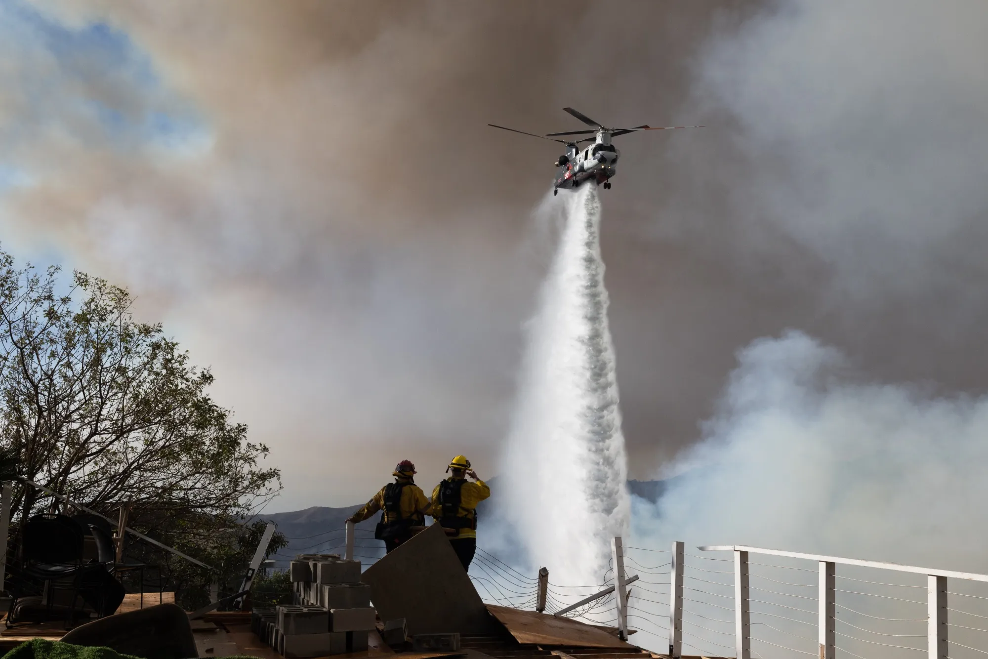 A helicopter drops water on the Palisades Fire near the Sullivan Canyon area of Los Angeles&nbsp;on&nbsp;Saturday.