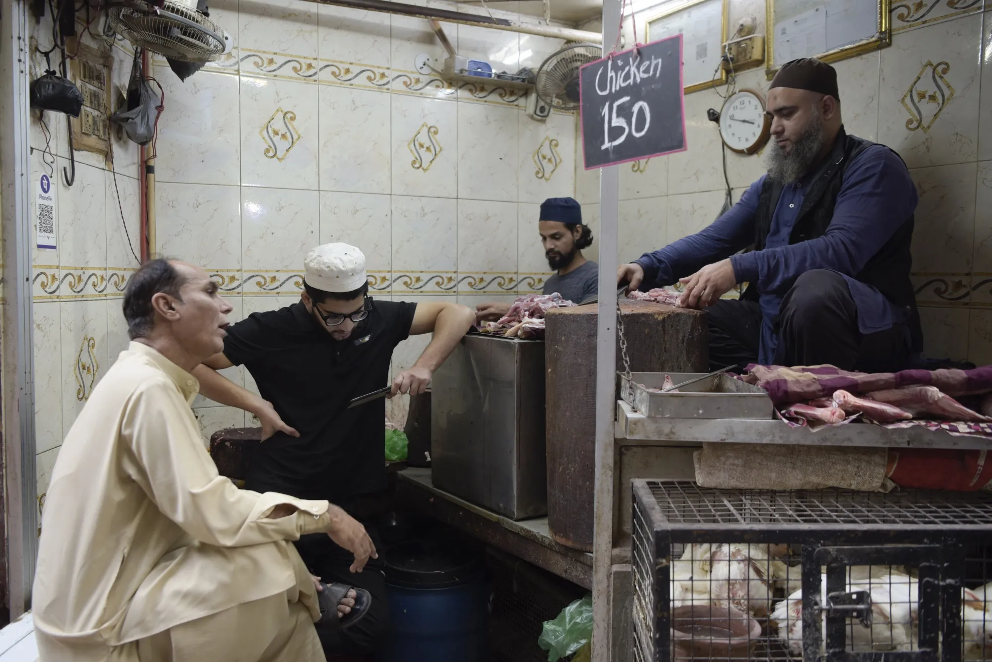A person watches the ICC Men’s Cricket World Cup final match between India and Australia on a mobile phone at a butcher's shop in Old Delhi, India. One of the team’s players was hampered by dengue, whose rates are on the rise.