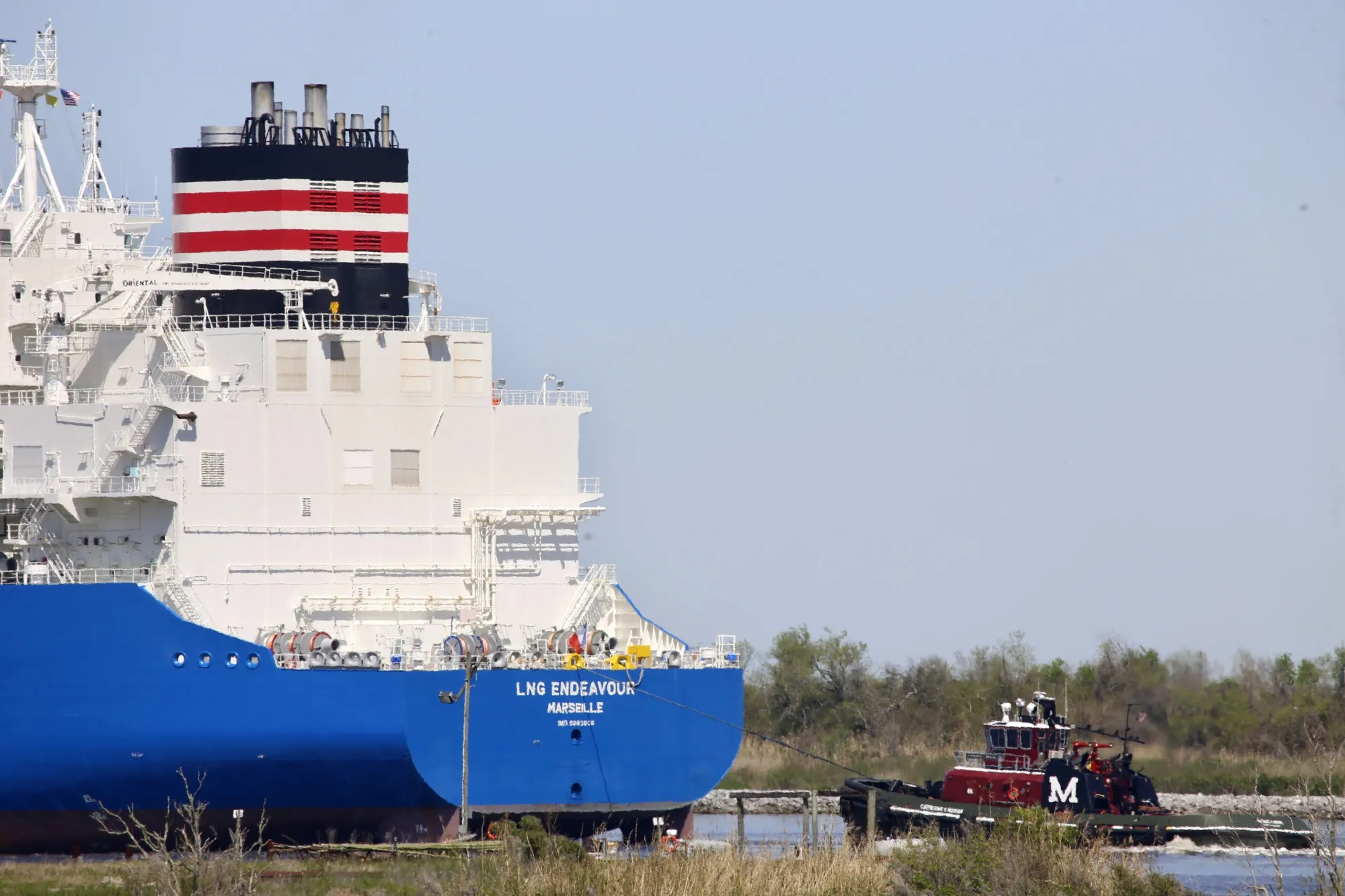 A tugboat helps guide a French ship, known as the LNG Endeavor, through Calcasieu Lake near Hackberry, La., on March 31, 2022. Russia’s war against Ukraine shattered its relations with Europe, which soon lost most of the natural gas that Moscow had long provided. Now, as winter nears, European nations have backed a short-term fix set to begin before the end of 2022 that has raised alarms among scientists who fear the long term consequences for the climate. (AP Photo/Martha Irvine, File)
